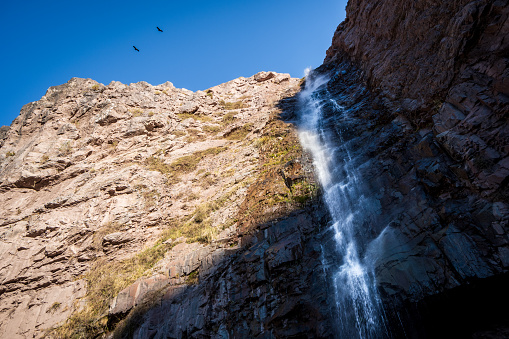 Waterfall on a rocky cliff in Cajon del Maipo, central Chile Andes