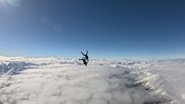 Free fall jumpers soar above mountain landscape