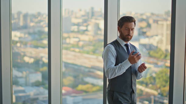 istock Stressed leader thinking decision tossing ball at cityscape. Pensive bearded man 2141564270