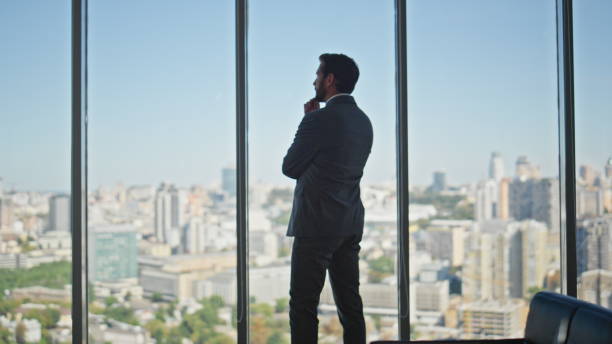 istock Thoughtful man looking panoramic window in office. Legal manager contemplating 2141585857