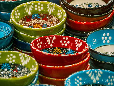Array of handmade uniquely designed porcelain plates, focused on red plates.