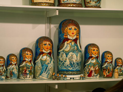 Various beautiful matryoshka dolls for sale on the shelf in a souvenir shop.