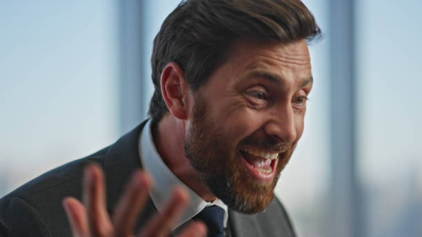 istock Closeup happy businessman celebrating triumph talking on virtual conference. 2141611254