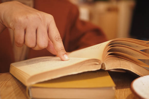 istock women hand holding a book at library 2141611794