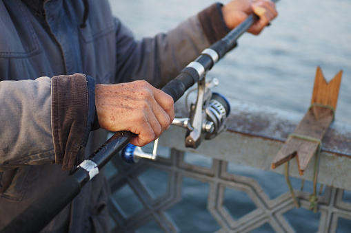 Fisherman with rod, spinning reel