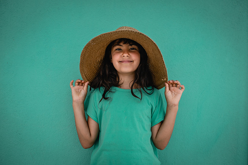 Summer portrait of a little girl wearing a large hat