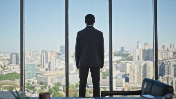 istock Confident leader standing office in suit looking panoramic window rear view. 2141676255