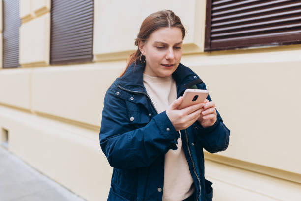 istock Upset sad, skeptical, serious woman with backpack holding smartphone gadget for communicate outdoors. Negative people emotion, Urban lifestyle concept. Angry 30s girl reading bad news 2141678355