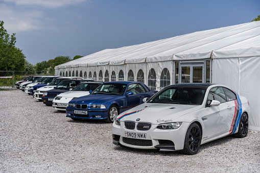 Holywell, Flintshire, Wales, May 13th 2023. BMW M3 with a row of sports cars parked outside of the white tent at an auction.