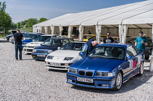 Holywell, Flintshire, Wales, May 13th 2023. People looking at a BMW M3, Nissan 300 ZX, Renault 5 GT and Mitsubishi EVO at a classic car auction.