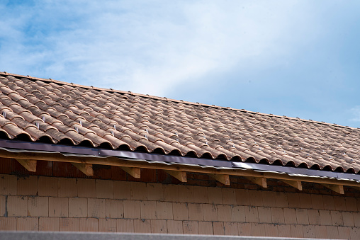 Ceramic roof tile on house against blue sky