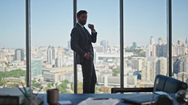 istock Thoughtful businessman standing panoramic window. Pensive boss silhouette alone 2141687392