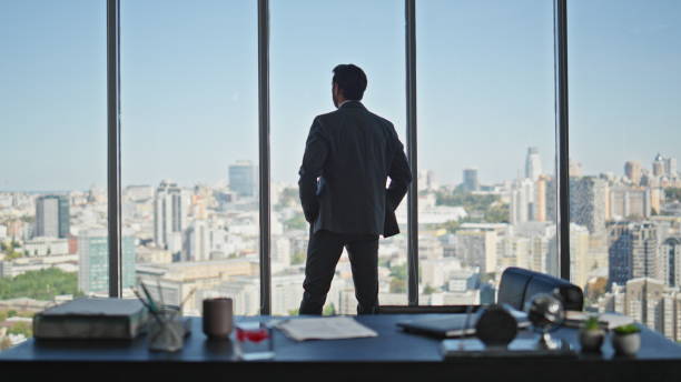 istock Manager silhouette contemplating city in panoramic office. Company ceo thinking 2141695285