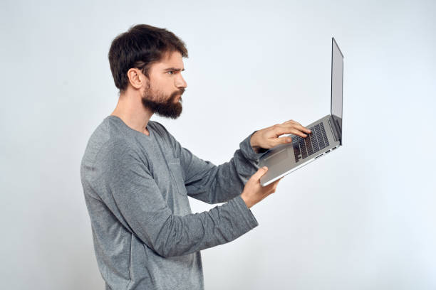 istock Bearded man with laptop in hands internet communication technology light background 2141708946