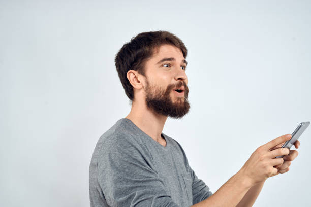 istock A man with a tablet in his hand internet technology communication gray jacket light background 2141719032