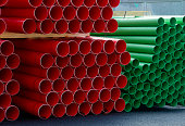 Plastic ducts stacked for underground cables at construction site