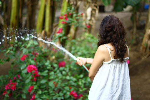 Young woman watering with a hose