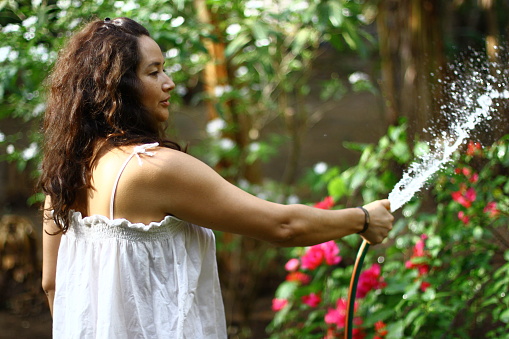 woman watering her garden with a hose