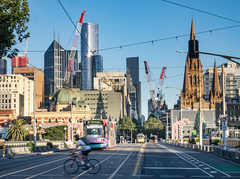 Melbourne's St Kilda Road, tram and crossing cyclist early morning