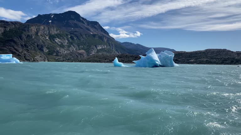 A large body of water with a few large ice blocks floating on it