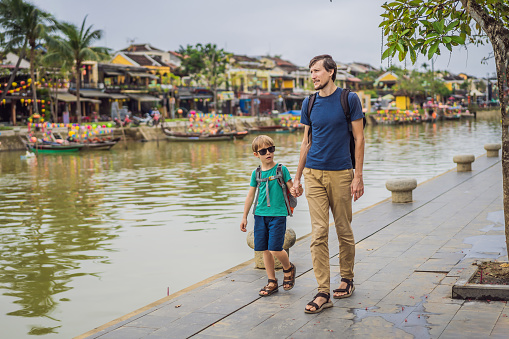 Dad and son travelers on background of Hoi An ancient town, Vietnam. Vietnam opens to tourists again after quarantine Coronovirus COVID 19.