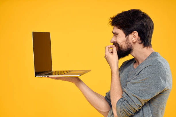 istock man with laptop wireless technology internet lifestyle work yellow isolated background 2141839056