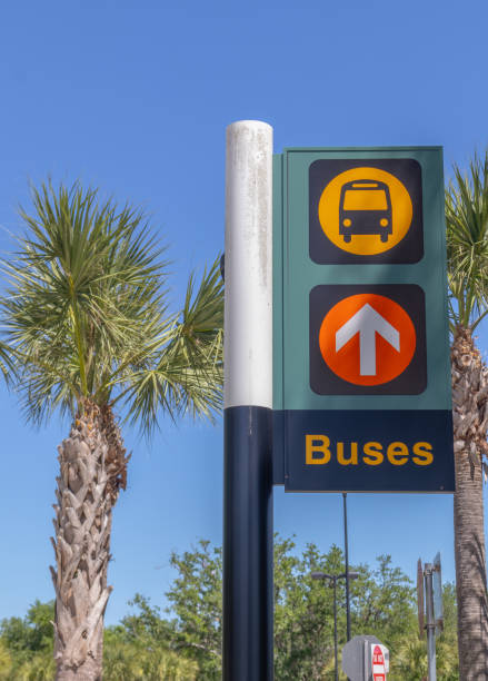Vertical view of directional sign with arrow and bus icon, leading passengers to buses with copy space