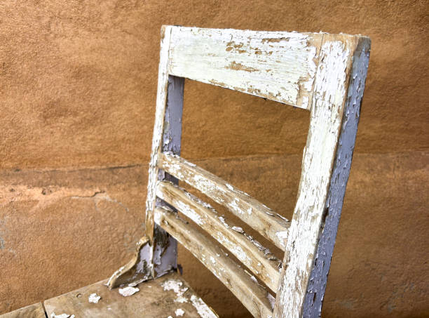 Antique Rustic Farmhouse Spindle-Back White Wood Chair. Copy space on the white wall.