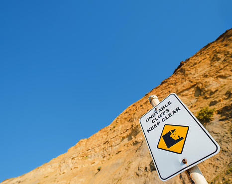 Sign cautioning to keep clear of unstable cliffs at Jan Juc beach, Surf Coast Shire, Great Ocean Road, Victoria, Australia