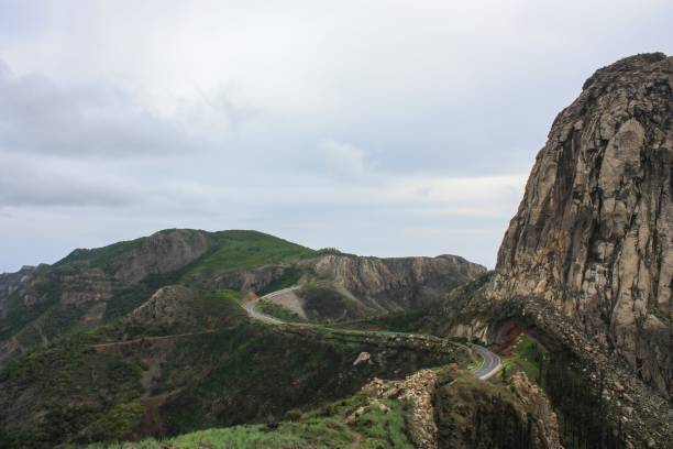 la sinuosa carretera se abre paso a través de imponentes montañas y escarpados acantilados, españa. - steep road footpath moving down fotografías e imágenes de stock