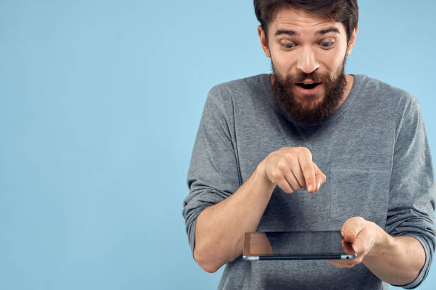 istock Man with tablet in hands technology lifestyle wireless device blue background 2141965057