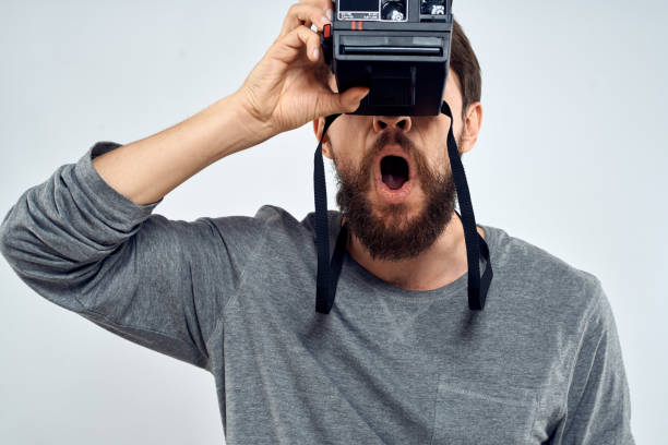 istock male photographer holding camera professional lens creative studio work light background 2141984034
