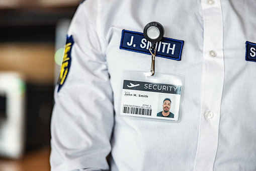 Photo of a Black male airport security workers credentials.