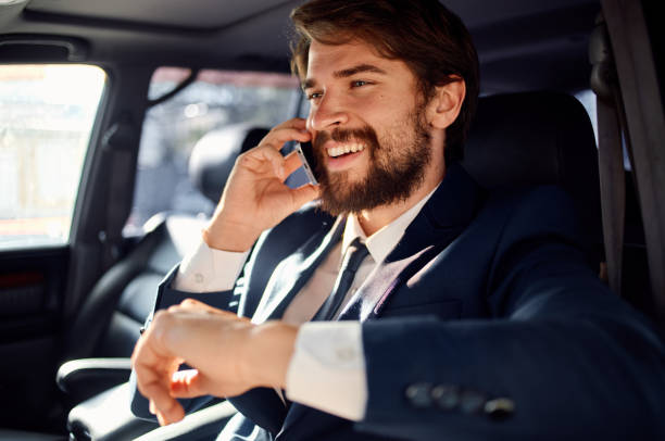 istock successful rich man in a suit talking on the phone while driving a passenger car 2142017702