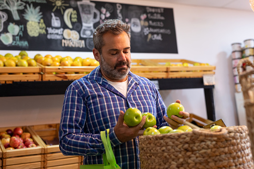 Mature Hispanic American man shopping in a greengrocer and diet store - Buenos Aires - Argentina