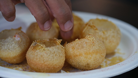 The dish is a type of chaat and originates from the city of Mumbai. It is served with mini-puri shells (golgappa)