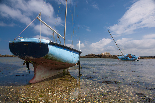 Blue yacht, high and dry at low tide.