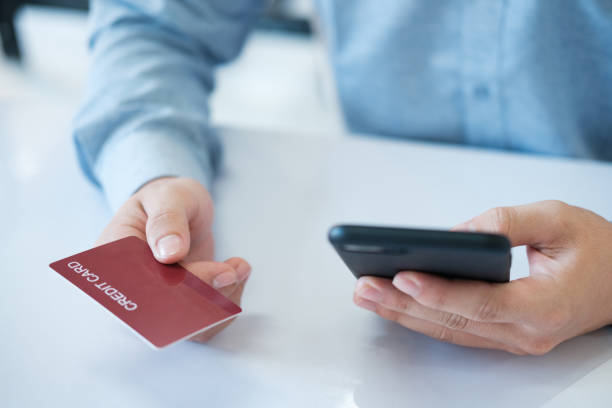 istock A man is using his phone to pay for something with a credit card 2142124386