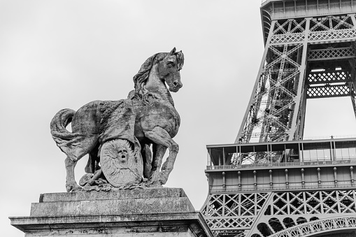 Paris, France - December 26, 2023:  A horse statue on Pont d'lena with Eiffel Tower in the background as viewed from the bridge.  HDR encoded