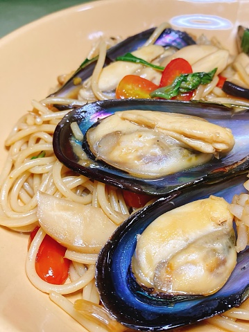 a photography of a plate of pasta with musselling and clams.