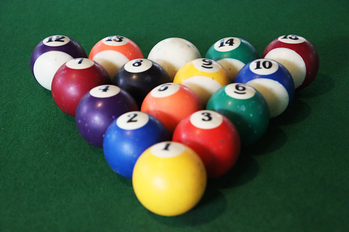 Creative photography of colourful billiard balls arranged in triangular shape.