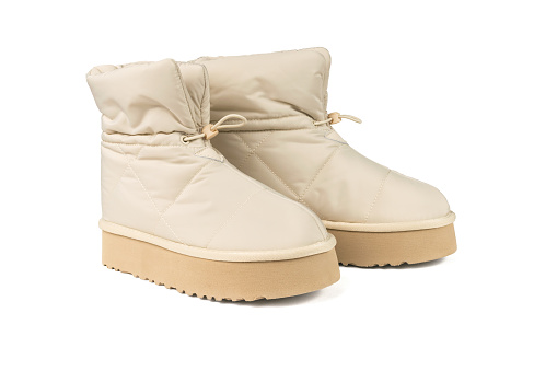 A pair of warm beige women's boots isolated on a white background. Women's shoes for cold weather.
