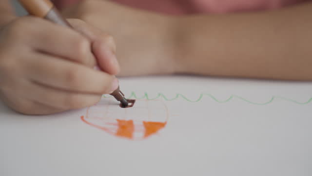 Little girl's hands drawing using colored felt tip pen