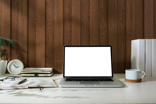 istock Laptop with white blank screen, notebook, coffee cup and glasses on wooden table. 2142330687
