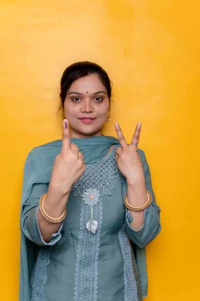istock Happy Indian young woman showing finger after voting over isolate background. 2142392597