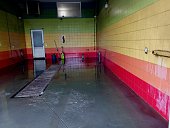 It is a multi-colored car wash with walls covered with colored tiles and objects that are used to wash the car. The premises are equipped for washing and cleaning cars