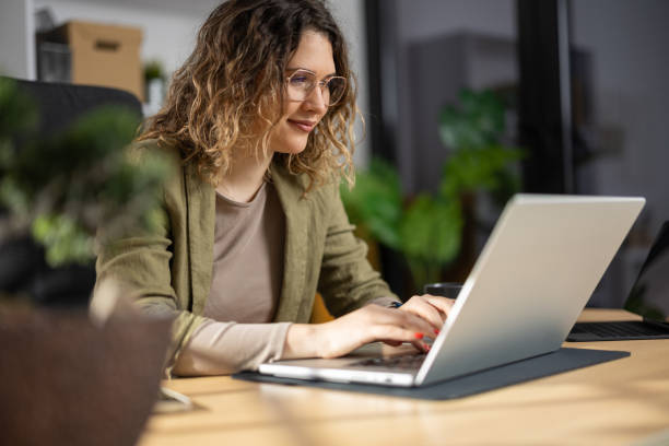 istock Motivated young woman working on laptop from home office 2142496157