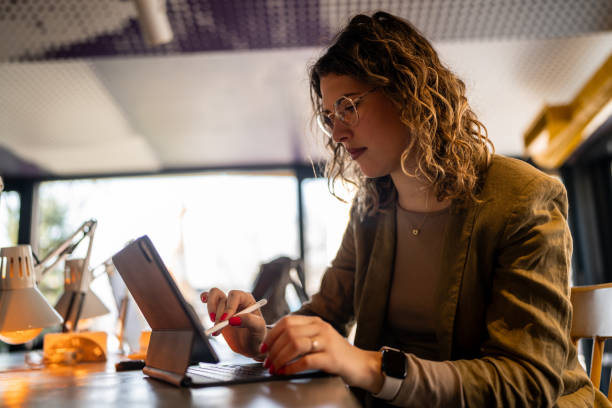 istock Young female graphic designer  drawing on digital tablet with digitized pen at coffee shop 2142497732