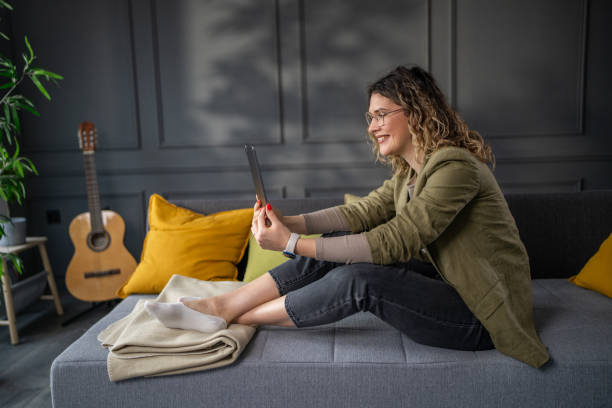 istock Young woman chatting with friends on digital tablet 2142498249