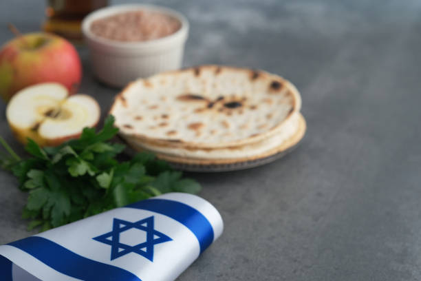 Jewish Passover celebrations. Handmade round Matzah in a plate on a concrete background. Saved Jewish Pesach Tradition. passover celebration stock pictures, royalty-free photos & images